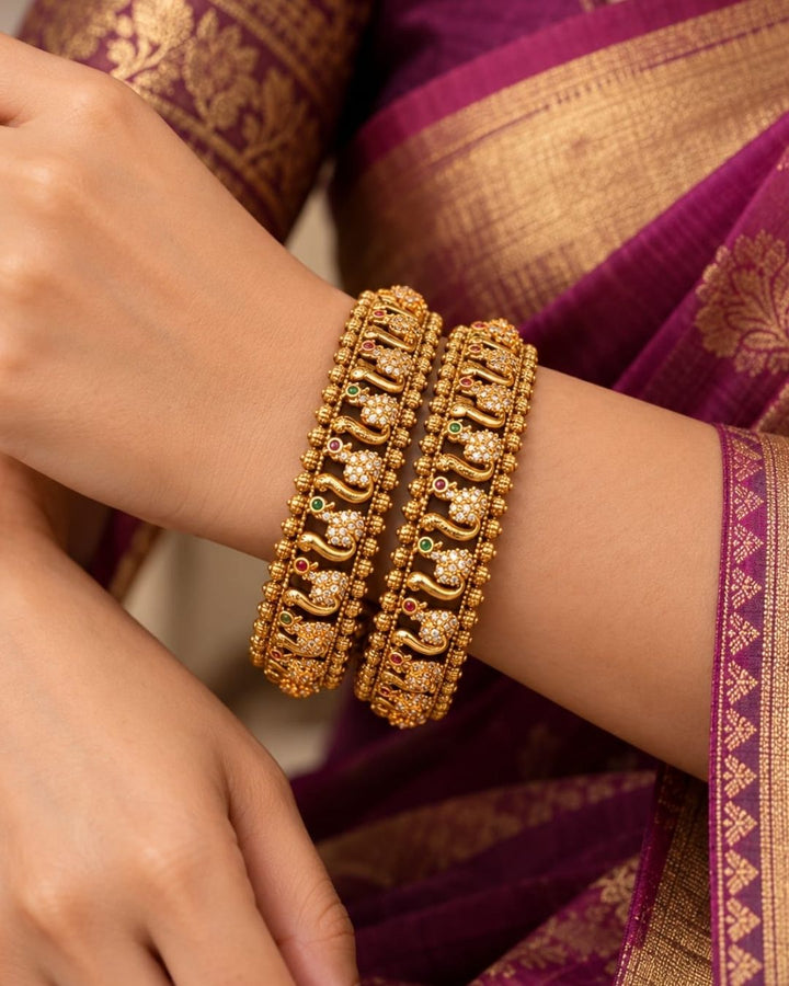 Premium gold plated designer bangles featuring repeating floral zircon motifs with textured gold bead detailing. Perfect for traditional wear, festive occasions, weddings, and gifting.
