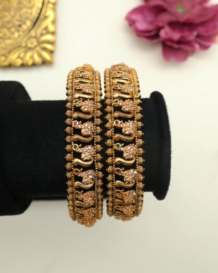 Premium gold plated designer bangles featuring repeating floral zircon motifs with textured gold bead detailing. Perfect for traditional wear, festive occasions, weddings, and gifting.