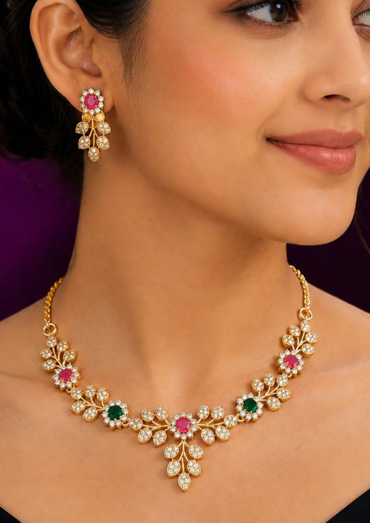 South Indian woman styling a zircon diamond gold plated floral necklace set with matching earrings. The jewelry showcases sparkling zircon stones, colorful pink and green gemstone accents and an elegant lightweight finish that pairs beautifully with sarees, lehengas, gowns and ethnic wear.
