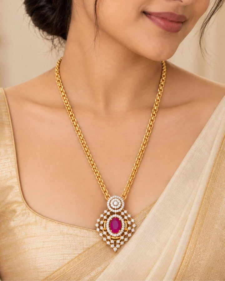 Designer gold plated necklace set featuring a layered chain, intricate zircon detailing, pink gemstone accents, and matching earrings, perfect for festive and traditional wear.