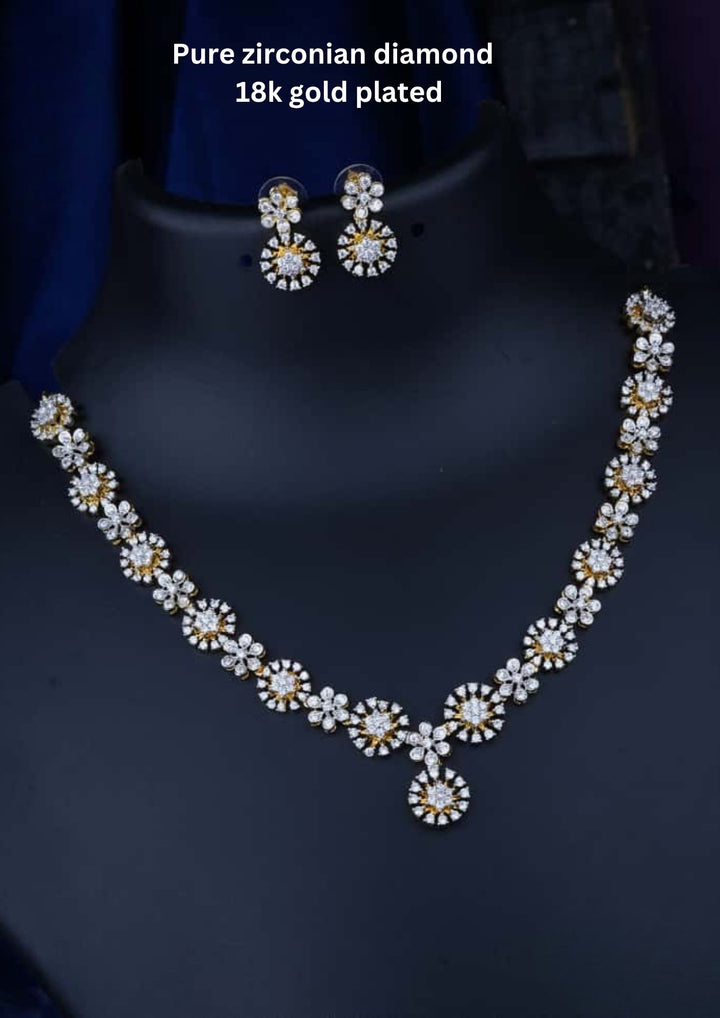 Necklace and earrings set with zirconian diamonds and 18k gold plating on a dark background