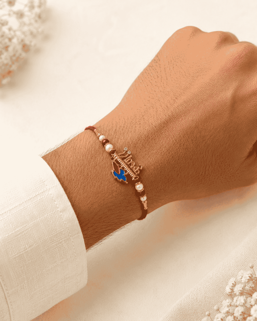 Premium Krishna Flute Rakhi with gold plated finish, peacock feather enamel charm, pearl accents, and red thread, perfect for Raksha Bandhan celebrations.