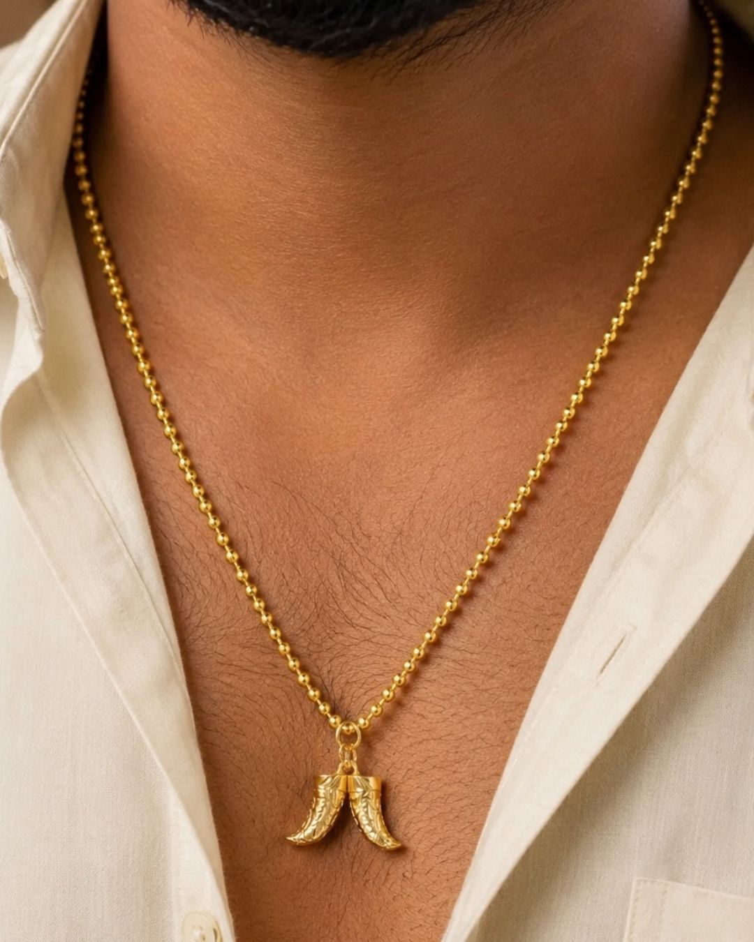 Beautiful gold plated necklace featuring a repeating beaded chain and a distinctive pair of curved horn-shaped pendants at the center. Perfect for traditional wear, festive occasions, weddings, parties, daily wear, and gifting.