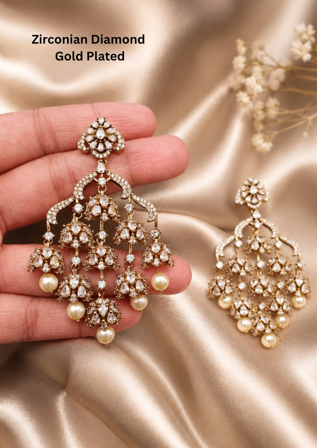 Modern Zircon Diamond gold plated heavy chandelier earrings. The design features a diamond-shaped top stud encrusted with white CZ stones, connecting to a wide arches layout. Suspended from the frame are three layers of small, delicate jhumka domes covered in sparkling American diamonds, finished with large hanging white pearls. Perfect for office, wedding, festivals