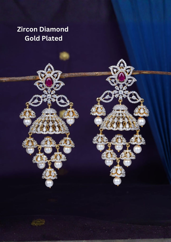 Gold-plated zircon diamond finish multi-tier jhumka earrings designed with dazzling CZ crystals, with a green tear-drop accent stone, and delicate hanging white pearls that give a red traditional and modern look for receptions, sangeet, luxury weddings, and party wear styling with lightweight comfortable use and COD available now.
