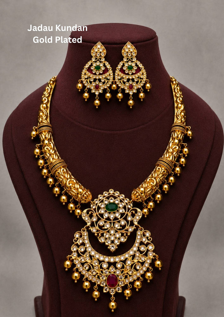 Gold plated short antique necklace and matching hanging earrings set featuring structured metal blocks filled with clear white Jadau Kundan stones. The center of the necklace highlights a slightly larger floral design stone layout, and the entire lower rim of both pieces is decorated with neat, hanging clusters of small round golden-cream pearl beads, providing a vintage traditional look suitable for weddings and family functions.