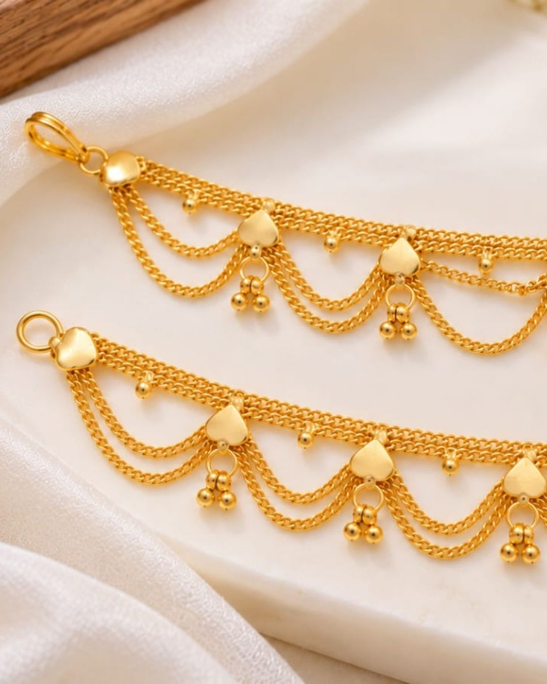 Gold plated traditional ear chains featuring multiple layered chain loops, decorative heart-shaped links, and tiny gold bead drops.