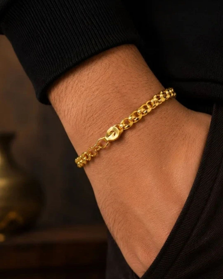 A close-up of a south indian man wrist wearing Elegant gold plated bracelet for men crafted with polished curb links and an adjustable clasp, perfect for daily wear, parties, traditional outfits, and gifting.