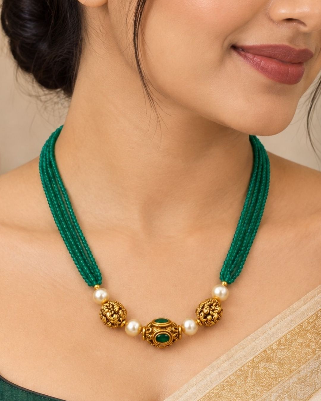 Traditional gold plated emerald beads necklace featuring multiple green bead strands, pearl accents, detailed gold motifs, and an elegant center pendant, perfect for festive and traditional wear.