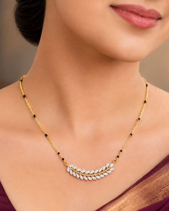 Traditional gold plated mangalsutra necklace with black beads and a delicate leaf-inspired CZ pendant, perfect for daily and festive styling.