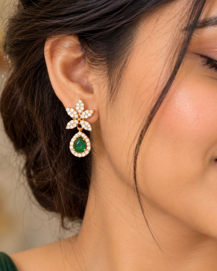 Designer gold plated necklace and earrings set featuring a delicate arrangement of leaf-shaped motifs embellished with sparkling white stones, a prominent green teardrop pendant, and matching green stone drop earrings, perfect for festive, wedding, and elegant occasions.