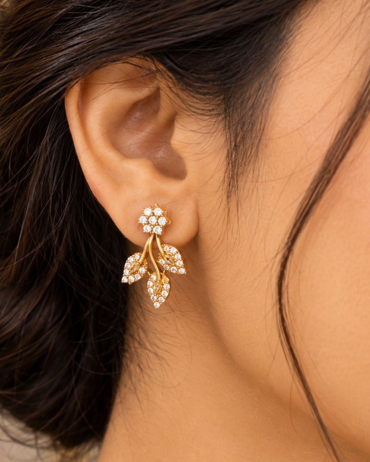 Designer gold plated necklace and earrings set featuring an elegant arrangement of leaf and floral motifs embellished with sparkling white stones, perfect for festive, wedding, and elegant occasions.