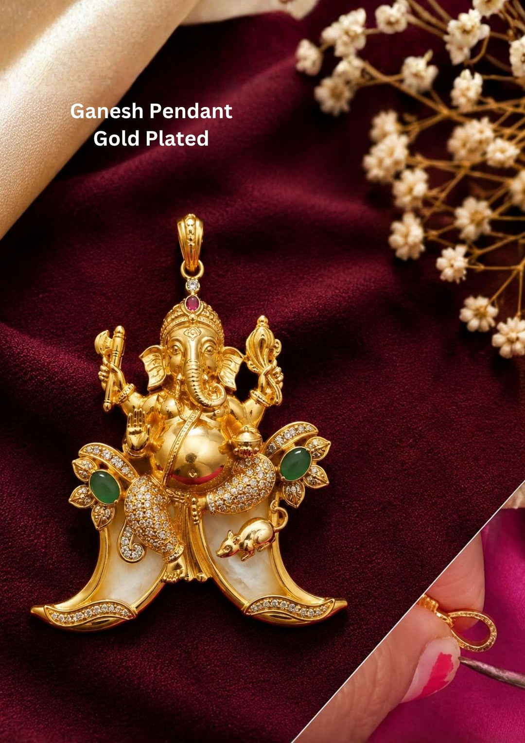 A traditional gold plated temple style pendant featuring an intricately sculpted idol of Lord Ganesha seated above a curved double tiger claw (pulinakha) motif. The piece is adorned with shimmering white crystals, ruby-red crown details, and green stone side accents, held up by a hand with blurred jewelry store displays in the background.