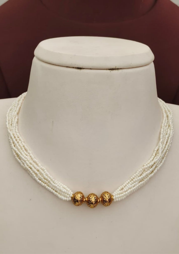 Premium white pearl beaded necklace featuring multiple delicate strands with three intricately patterned gold beads at the center. Perfect for traditional wear, festive occasions, weddings, parties, and gifting.