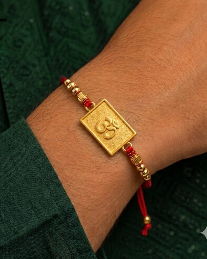Premium spiritual Rakhi showcasing an embossed Om symbol centerpiece with gold bead detailing and traditional red thread.