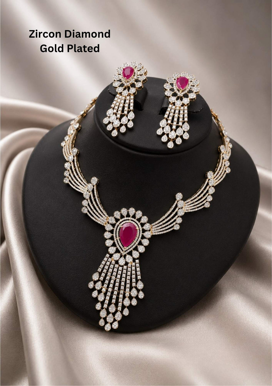 Pure zircon diamond luxury choker necklace set featuring a winged multi-layered diamond band holding a central floral pendant with a striking pink tear-drop ruby stone centerpiece and an elongated, tiered diamond fringe tassel. The matching hanging earrings boast a similar floral stud, pink ruby center, and cascading tiered diamond droplets.  suitable for weddings, receptions, parties, festivals, family functions.