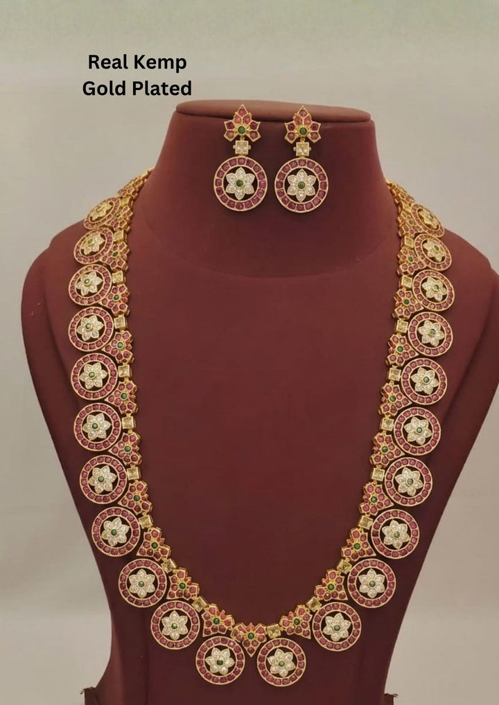 Elegant Jadau Kundan gold plated long necklace set featuring ruby-toned floral motifs with matching designer earrings for bridal and festive wear.