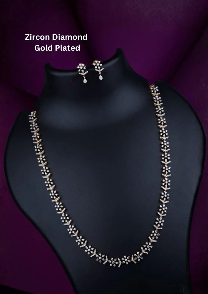 gold plated haram necklace set highlighting a continuous chevron chain pattern accented with delicate eight-pointed starburst clusters tightly encrusted with micro pure Zirconian diamonds. The bridal set comes complete with a matching pair of starburst dangle earrings featuring teardrop crystal drops.