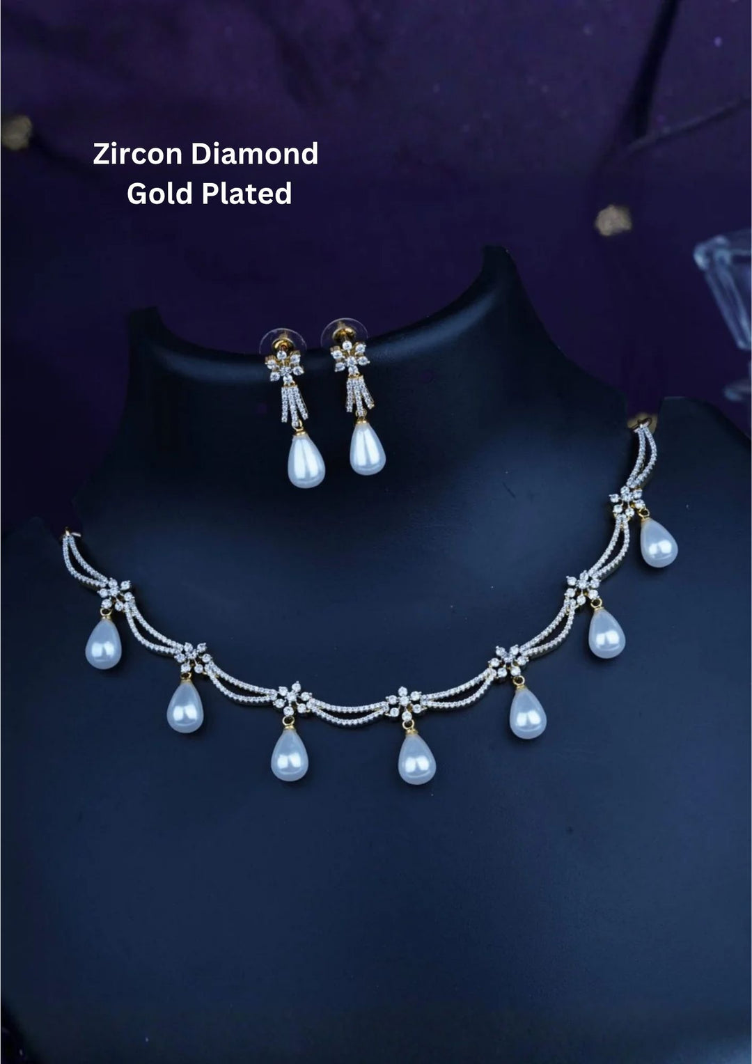 gold plated collar necklace crafted with a double-layered scalloped swag design, heavily paved with shimmering pure Zircon diamonds and accented with small flower star stations. Suspended from the swags are seven perfectly matched, smooth cream-white teardrop pearl drops, complete with matching pearl dangle earrings.