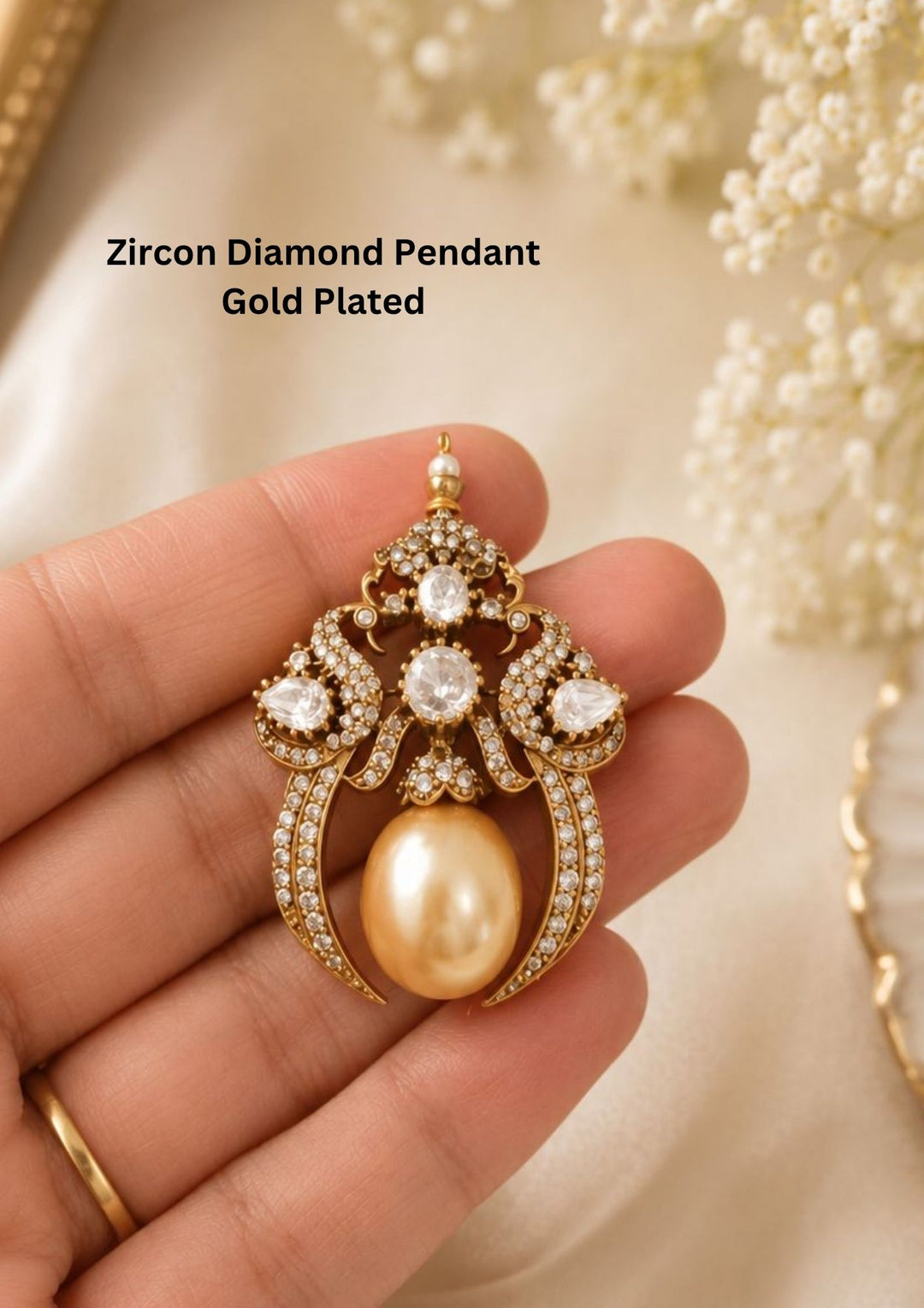 A premium gold plated statement pendant heavily encrusted with glittering white zircon diamonds in an elegant chandelier design. The piece features three large focal white crystals arranged down the center, flanked by sweeping diamond-studded crescent wings. A massive, high-luster golden teardrop pearl hangs gracefully from the bottom base as a stunning centerpiece.