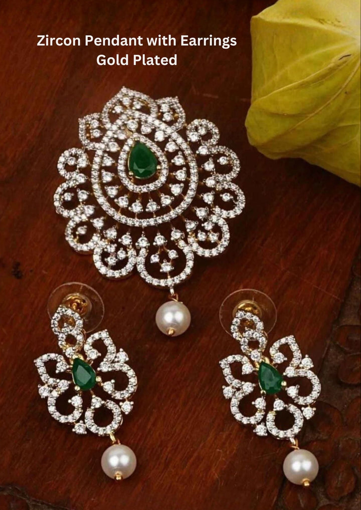 Elegant zircon diamond gold plated pendant set featuring a floral-inspired pendant designed with sparkling white zircon stones arranged in circular patterns. The centerpiece showcases a pear-shaped emerald green stone surrounded by dazzling zircon stones, finished with a delicate pearl drop. The matching earrings mirror the same floral design with green stone and pearl danglers, Perfect for weddings, festivals, office wear, functions and its anti fade color