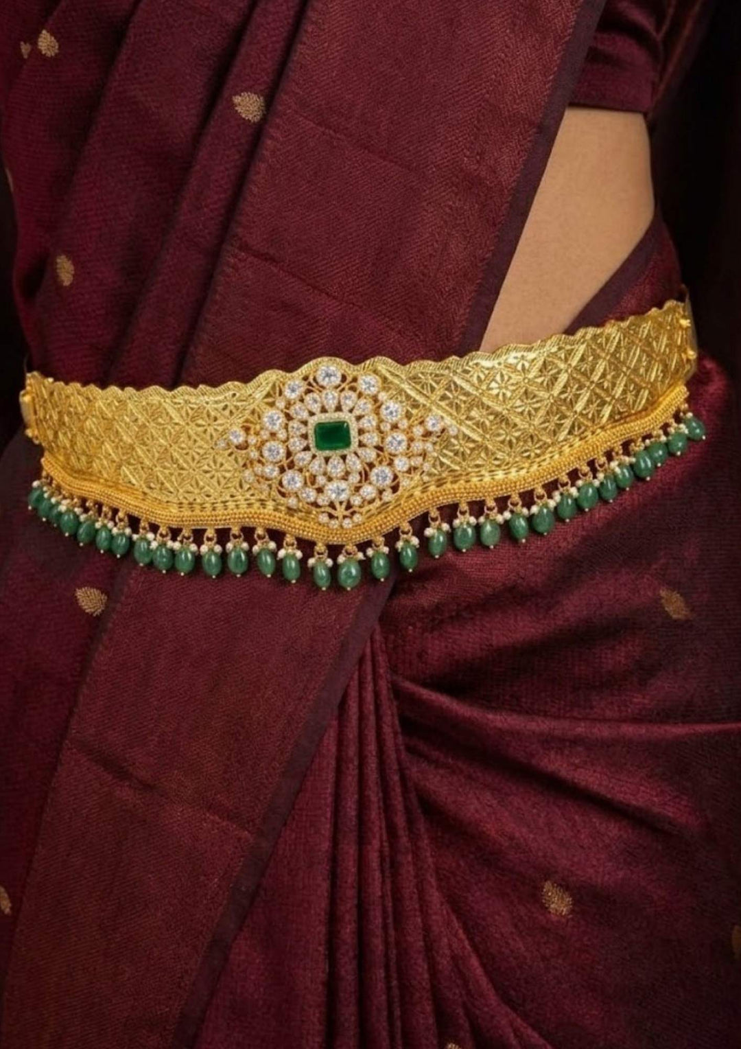 south Indian women wearing a traditional gold plated emerald beads adults hipbelt (vaddanam) for traditional look and in picture it shows very clearly how it looks and shine and can be used for festivals, weeding&