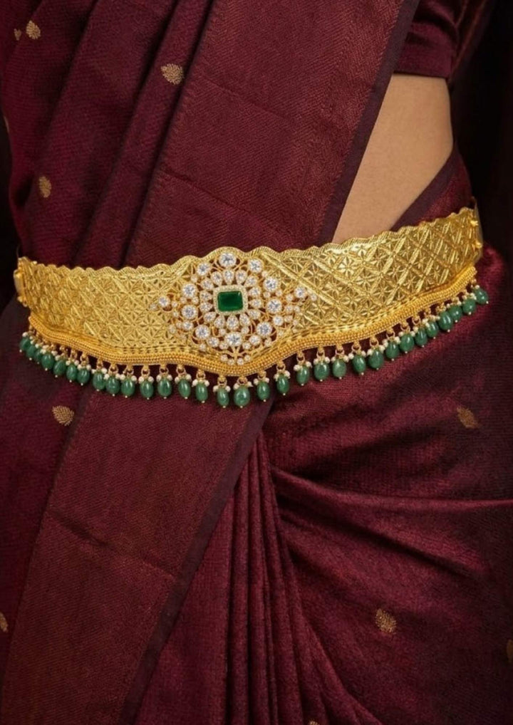 south Indian women wearing a traditional gold plated emerald beads adults hipbelt (vaddanam) for traditional look and in picture it shows very clearly how it looks and shine and can be used for festivals, weeding&