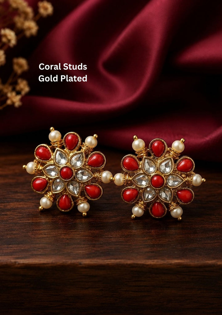 Elegant gold plated coral stud earrings featuring a beautiful floral design adorned with vibrant red coral stones, sparkling kundan-style crystals, and delicate pearl accents. Perfect for traditional occasions, festive celebrations, weddings, and ethnic wear.