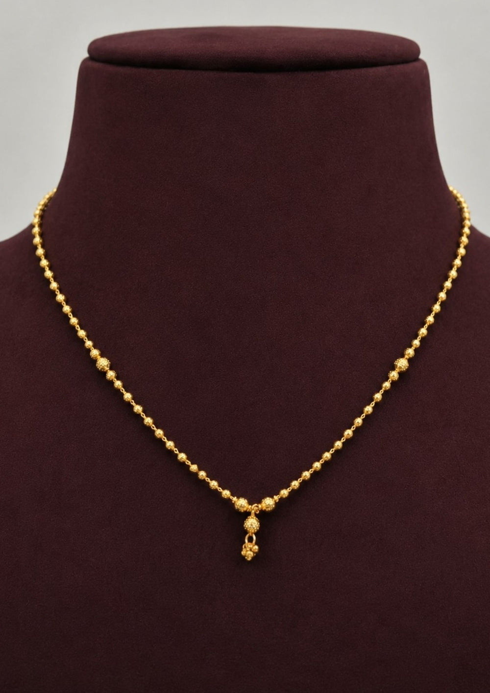 Minimalist gold plated necklace showcasing intricate textured bead detailing with a graceful drop pendant, perfect for daily wear, office wear, festive occasions, weddings, and traditional styling.