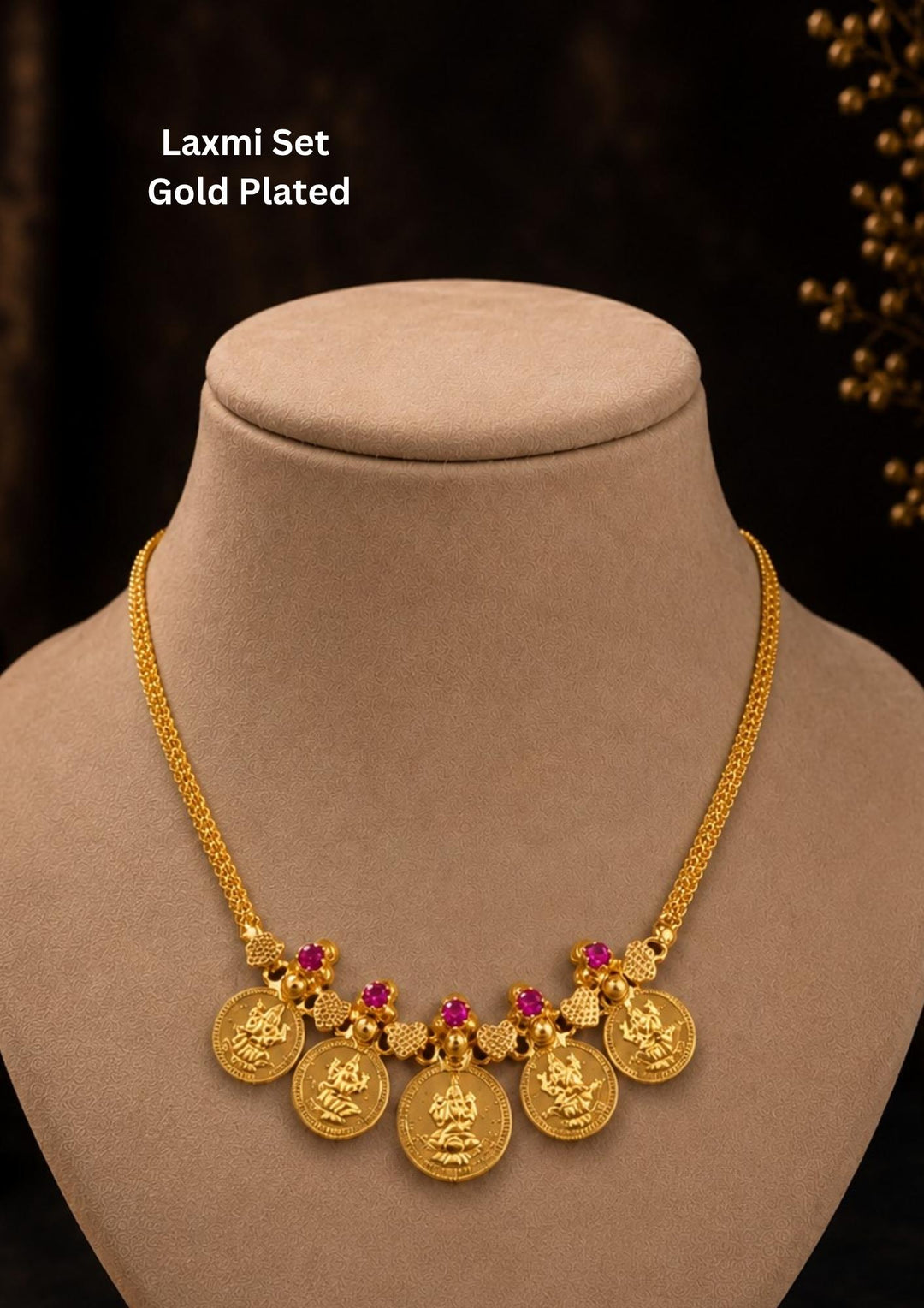 Exquisite Goddess Laxmi gold-plated coin necklace featuring intricate motif carvings and ruby-colored stone accents. Ideal for weddings, festive occasions, temple visits, traditional sarees, and bridal gifting.