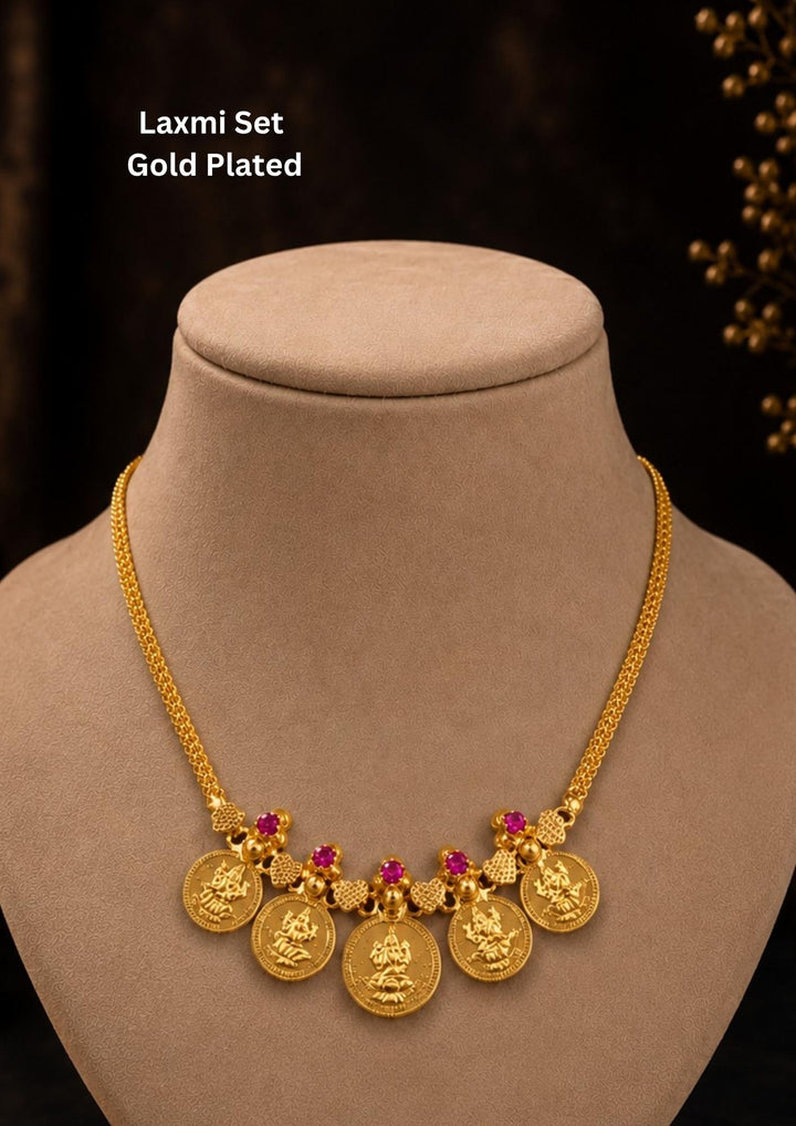 Exquisite Goddess Laxmi gold-plated coin necklace featuring intricate motif carvings and ruby-colored stone accents. Ideal for weddings, festive occasions, temple visits, traditional sarees, and bridal gifting.