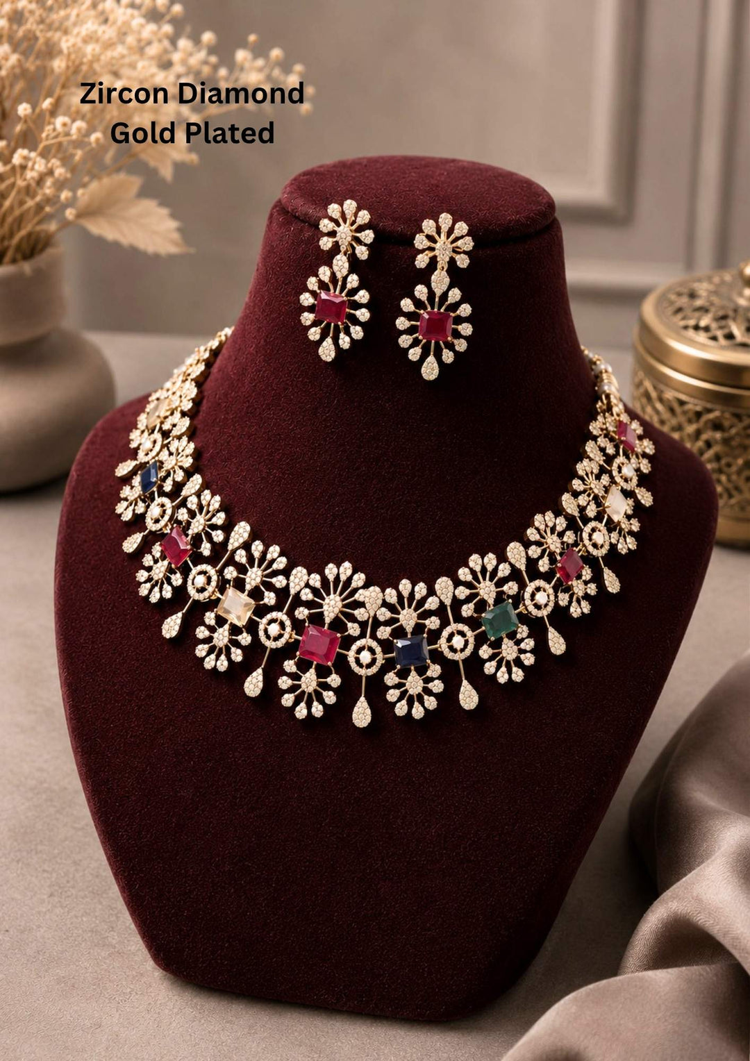Zircon diamond gold plated necklace set featuring an intricate floral cluster band studded with shimmering white CZ diamonds, interspersed with rectangular multi-color gemstones including ruby pink, emerald green, sapphire blue, and yellow topaz. The matching hanging earrings feature a floral top and a pink ruby stone center framed by diamond clusters. Perfect for weddings, parties, and festive celebrations with skin-friendly quality, comfortable fitting,