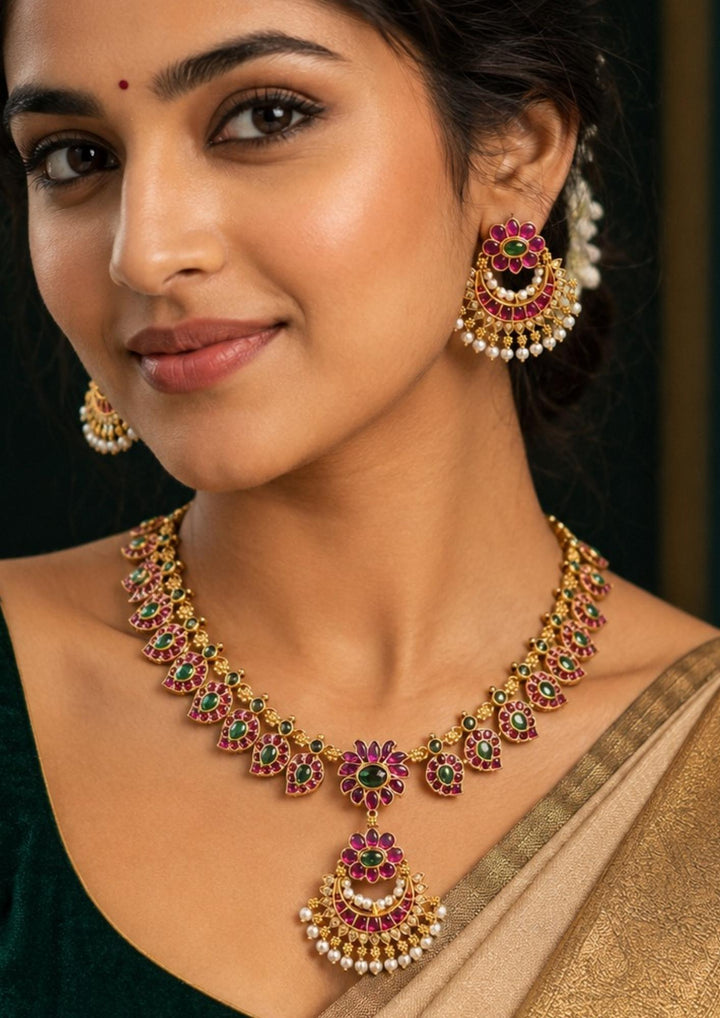 South Indian woman styling a jadau kundan gold plated floral necklace set with pearl earrings. The jewelry features colorful kundan stones, floral detailing and pearl danglers that beautifully complement sarees, lehengas and traditional attire.