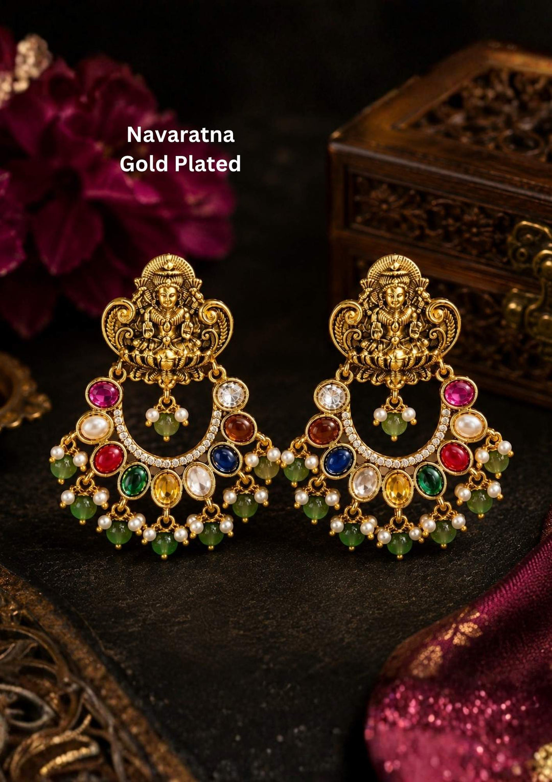 Traditional Lakshmi gold plated stud earrings featuring a beautifully detailed Goddess Lakshmi motif at the top, paired with an ornate chandbali-inspired design. The earrings are adorned with vibrant multicolor navaratna stones, sparkling zircon accents, pearl detailing and elegant green bead drops, creating a rich temple jewelry look ideal for weddings, festivals, poojas and traditional celebrations.
