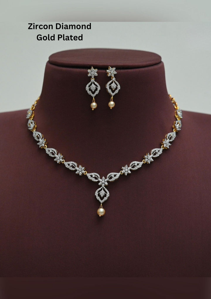 An elegant zircon diamond gold plated necklace set features a delicate V-shaped chain adorned with sparkling floral marquise stones and a central hanging pearl drop, complemented by matching floral teardrop earrings with pearl accents.