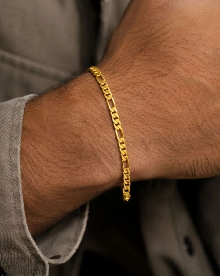 Close up of south indian men wrist wearing An elegant, sleek 18k gold-plated bracelet  features a continuous, sophisticated pattern of repeating cylindrical bar links seamlessly interconnected with small circular loops, offering a clean and polished modern look. Perfect for daily wear or for pairing with your favorite pendant.