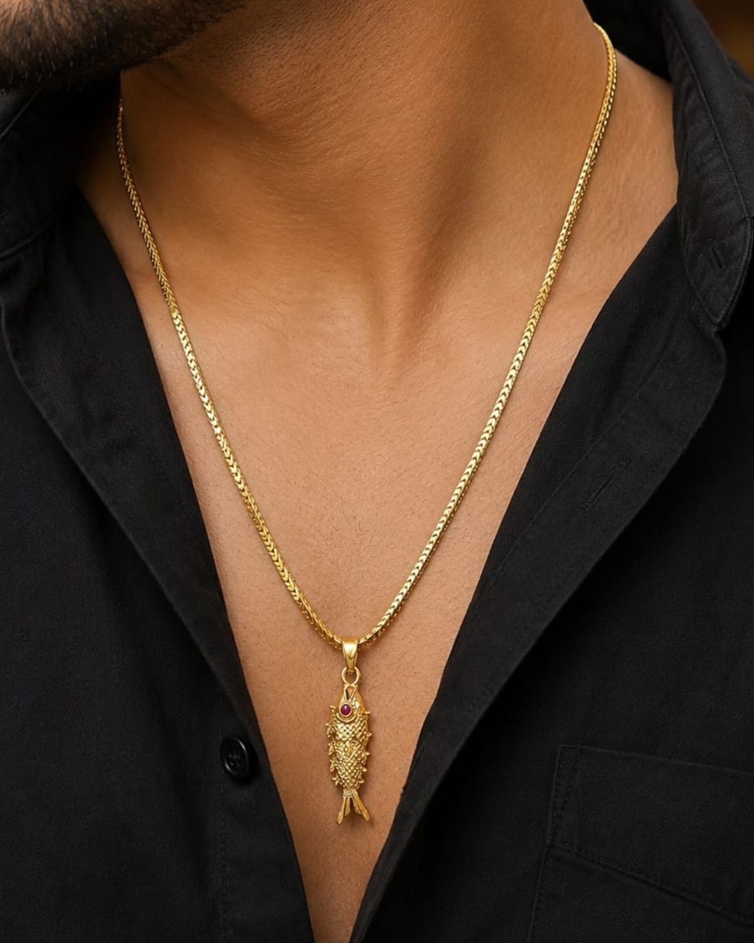 Traditional-inspired fish pendant with gold plated finish and matching chain, styled on a wooden background.