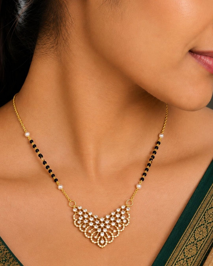 Beautiful black beads gold plated necklace set featuring a detailed floral pendant embellished with sparkling stones, paired with matching floral earrings. Perfect for daily wear, festive occasions, parties, and gifting.