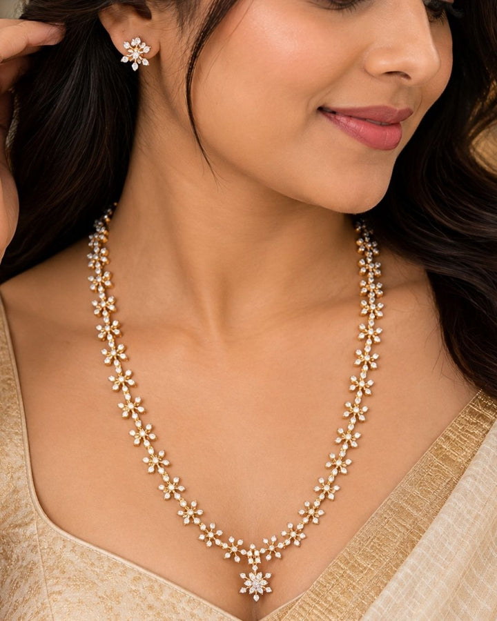 Zirconian Diamond Gold Plated long chain necklace and matching stud earrings set. The jewelry designed with floral pattern made of sparkling cube zirconia stones on a gold-plated base for festivals, temple visits, weddings, functions and dailywear