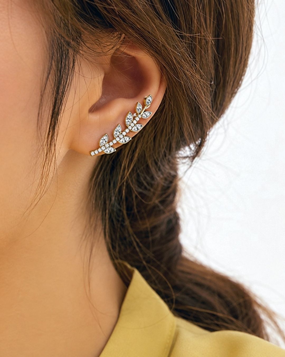 Stylish open ear cuff with gold plated detailing, leaf-shaped zircon accents, and sparkling stone embellishments.