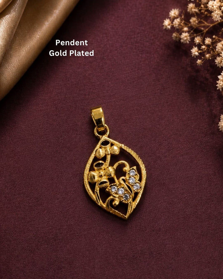 Beautiful gold plated leaf pendant featuring intricate floral patterns and CZ-style stones on a rich maroon background.