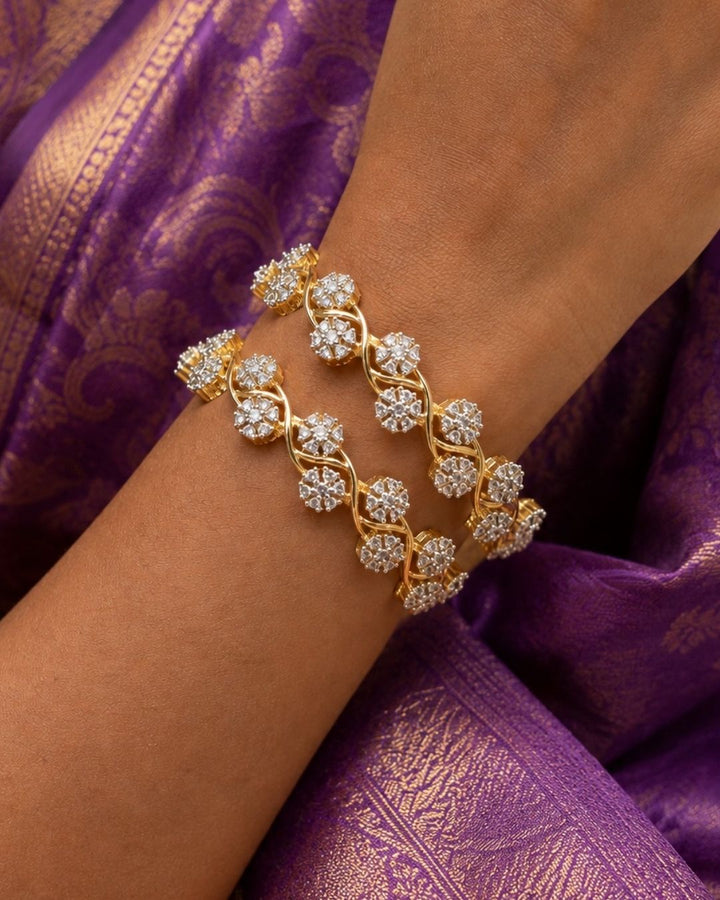 A woman viewed from the back wearing an ornate traditional Indian gold hair ornament (jhumka-style hair chain) on her long black hair, paired with a deep maroon and gold saree.