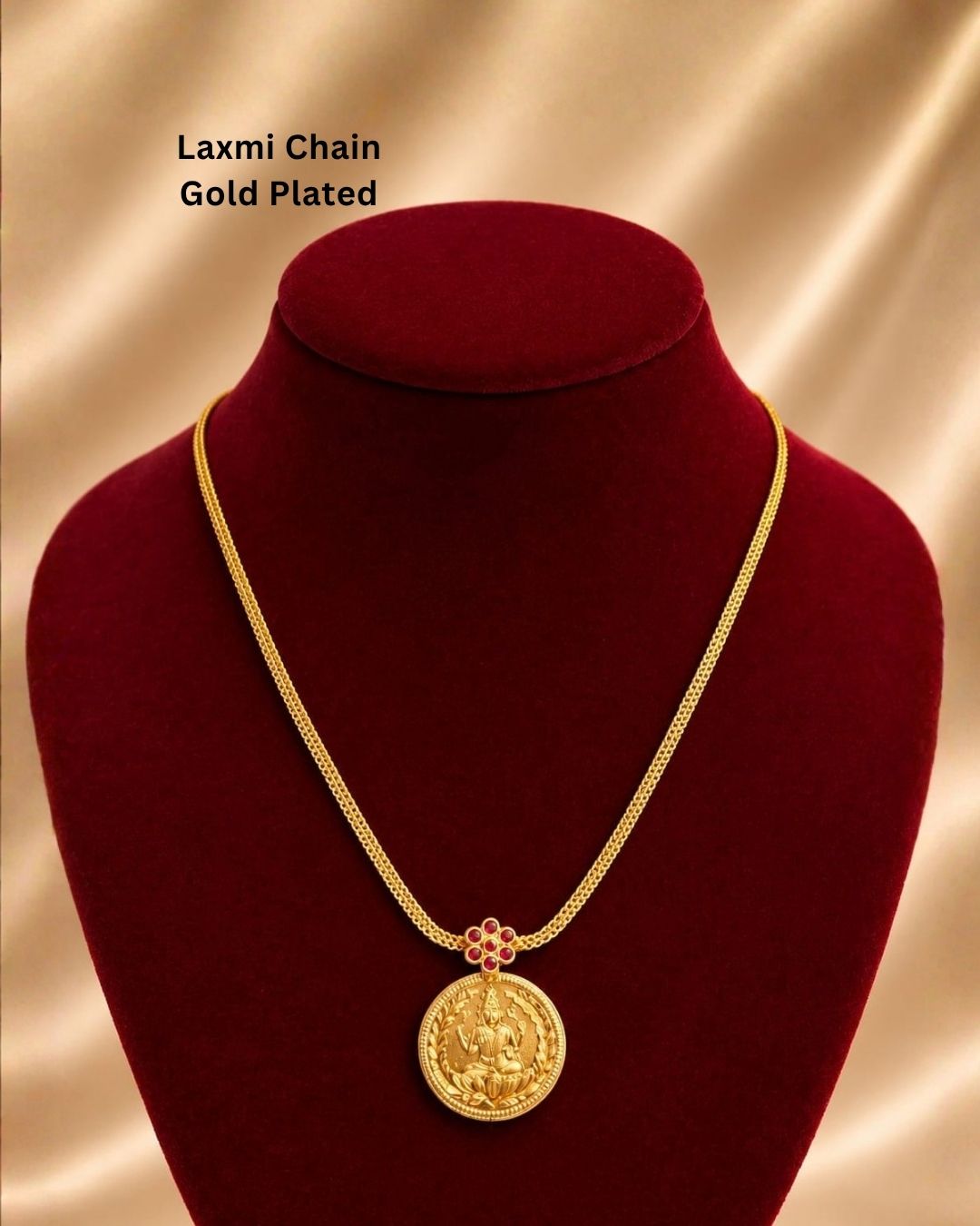 gold necklace with a coin pendant Laxmi chain gold plated traditional necklace featuring a circular coin pendant embossed with Goddess Lakshmi seated on a lotus, connected by a small pink ruby stone floral accent to a thick textured mesh chain. This classic South Indian style necklace is crafted with a premium gold finish that provides a rich divine appearance suitable for weddings, festivals, poojas, family functions, Varalakshmi Vratam, Diwali, sarees, and ethnic outfits with skin-friendly