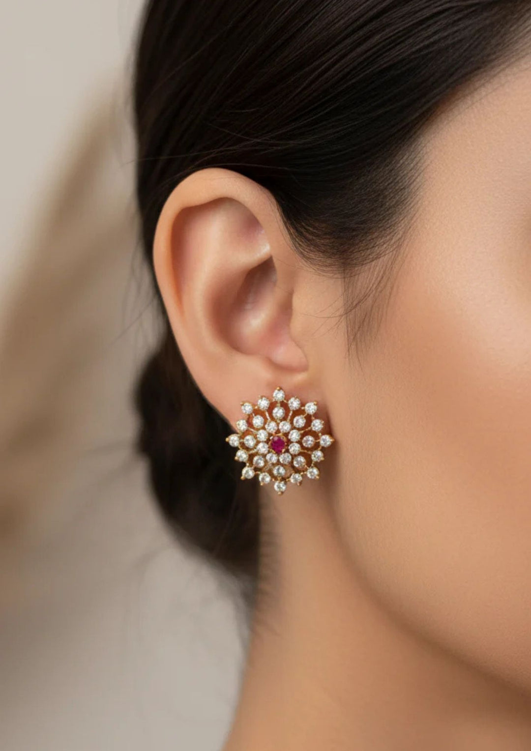 Close-up of an ear wearing a red gemstone studs and close see the detailing of the studs with shine and  classy look can be used for dailyware, functional ware and for gifting 