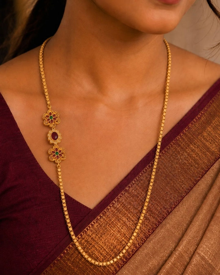 Beautiful floral gold plated long chain featuring intricate temple-inspired craftsmanship, ruby-colored stone accents, and a lightweight beaded design. Perfect for weddings, festive occasions, traditional outfits, temple visits, and premium gifting.