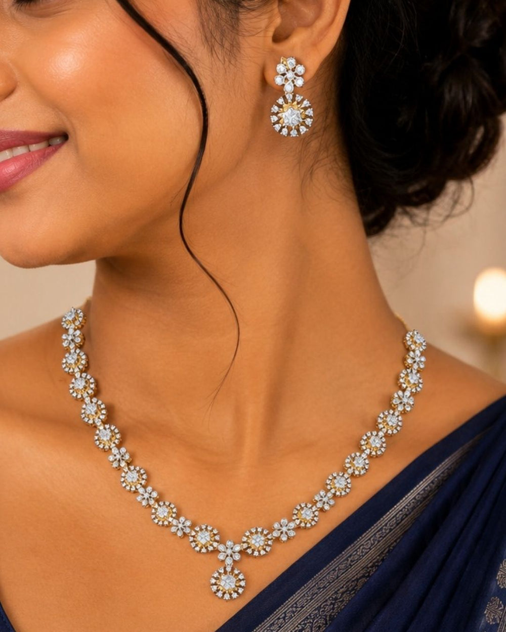 A close-up lifestyle shot of a woman wearing a matching silver-toned jewelry set, featuring a floral necklace and matching drop earrings. The jewelry is embellished with clear stones and set in silver-toned metal.