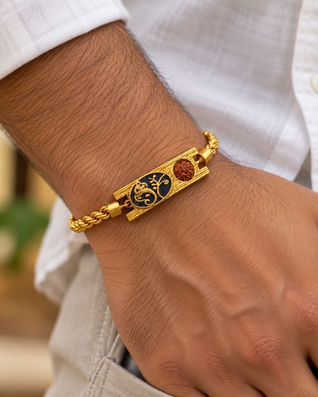 Stylish gold plated men’s bracelet featuring a braided chain, ornate rectangular centerpiece with black enamel detailing and a textured bead accent, perfect for daily wear, festive occasions, and traditional styling.