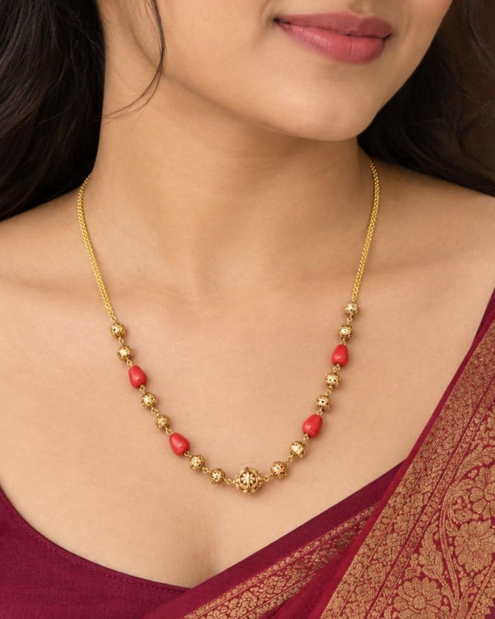 Traditional gold plated coral mala necklace featuring alternating red coral beads and intricately detailed gold beads, finished with a decorative central pendant, perfect for festive and traditional wear.