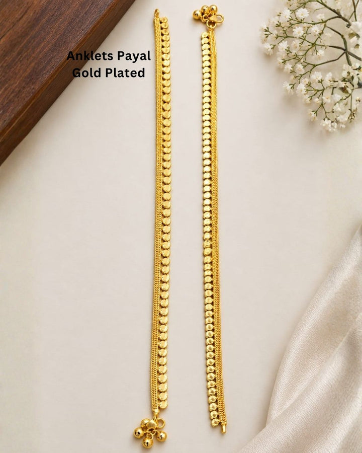 Beautiful gold plated payal featuring layered chain detailing and a repeating pattern of round coin-like elements, finished with charming ghungroo accents. Perfect for traditional wear, festive occasions, weddings, daily wear, and gifting.