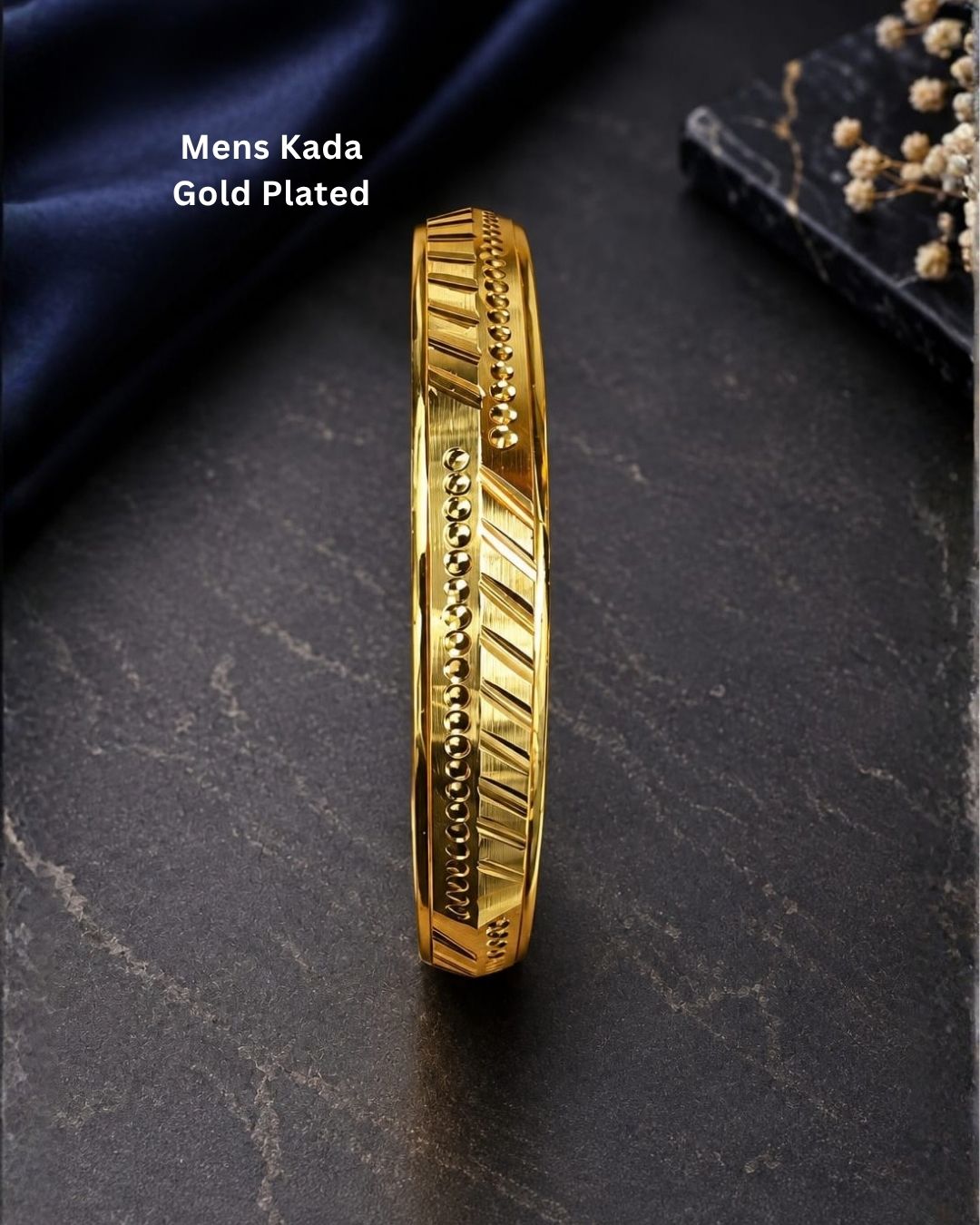 Gold plated men’s kada displayed upright on a dark textured surface, highlighting its geometric detailing and glossy finish.